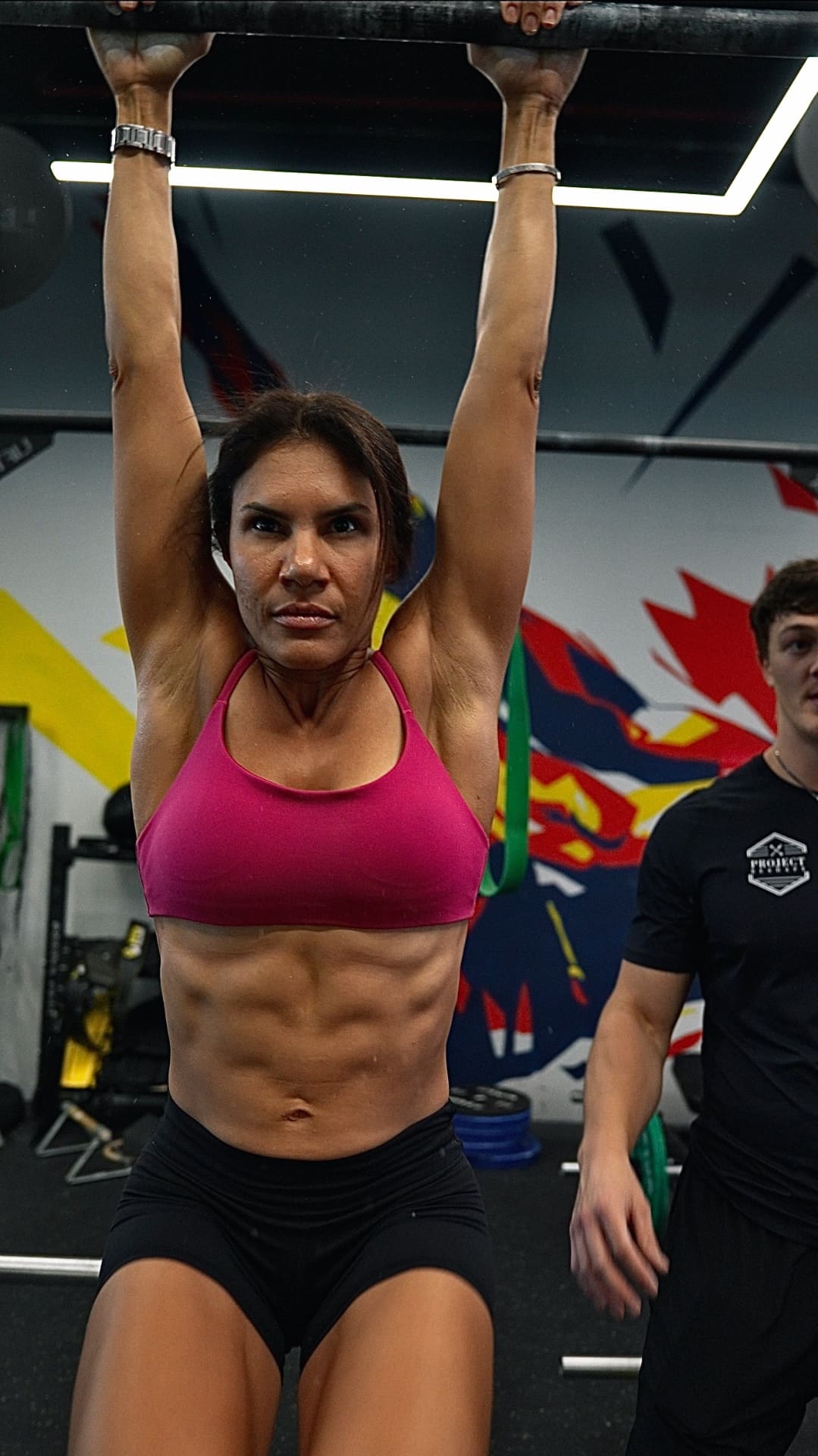 Coach observing a client mid-squat at the studio
