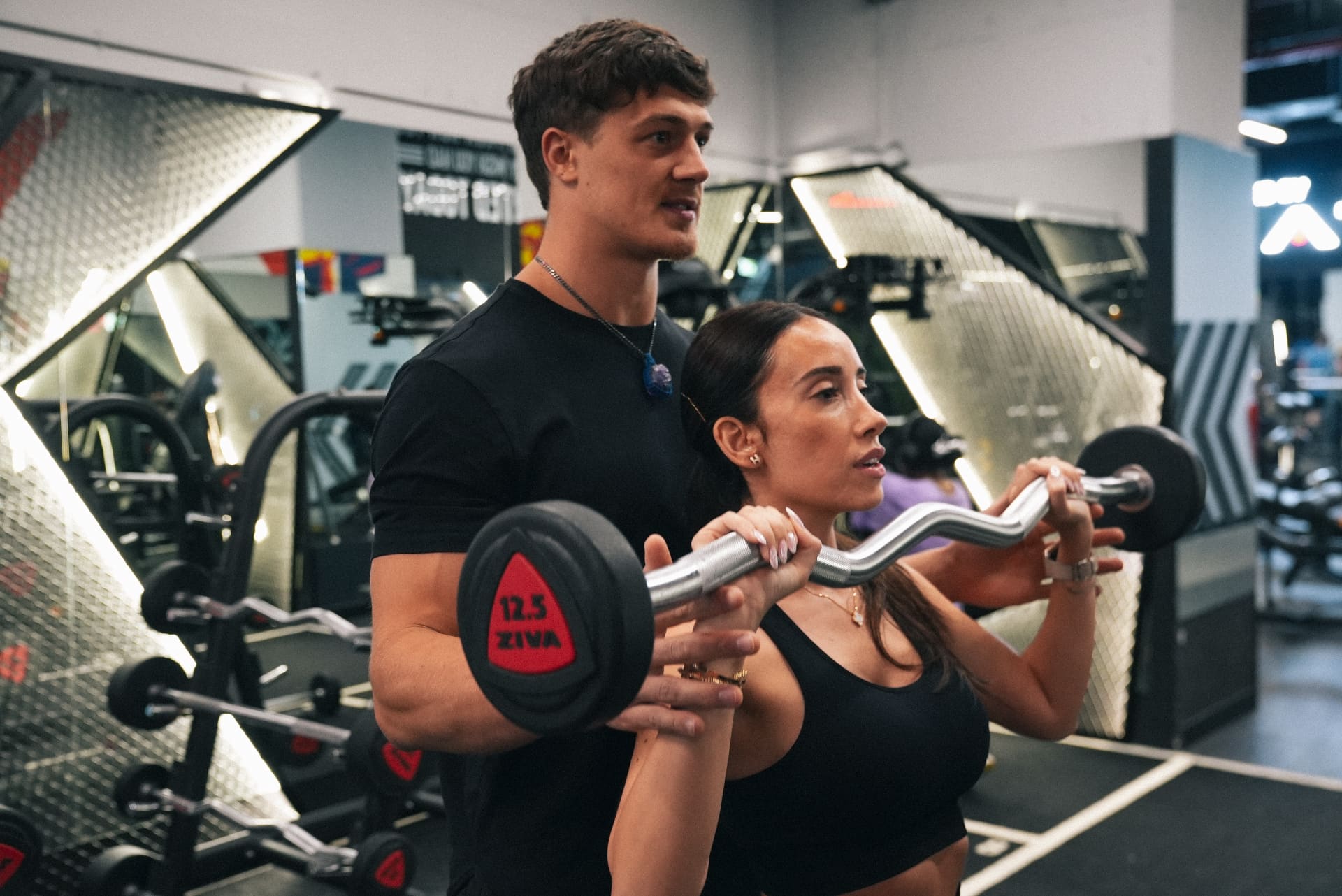 Project Reshape coach guiding a client through a barbell curl